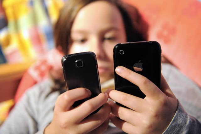 A child using mobile phones. Image for illustration only. (Photo by DENIS CHARLET/AFP via Getty Images)