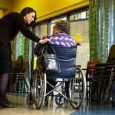 Nurse in a care home talking to an elderly woman in a wheelchair