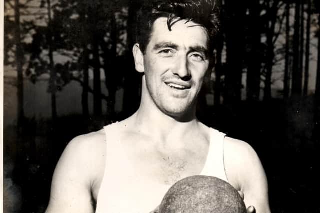 A young Bob Aitken holds a stone putt