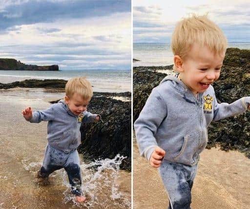 Barefooted and having a blast: Little Juliusz loved a day out at the beach splashing about.