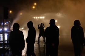 Police officer use water cannon as they clash with youths in the Springfield Road area of Belfast (Picture: Paul Faith/AFP via Getty Images)