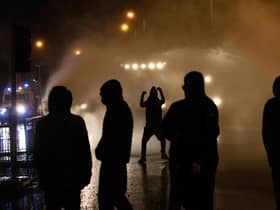 Police officer use water cannon as they clash with youths in the Springfield Road area of Belfast (Picture: Paul Faith/AFP via Getty Images)
