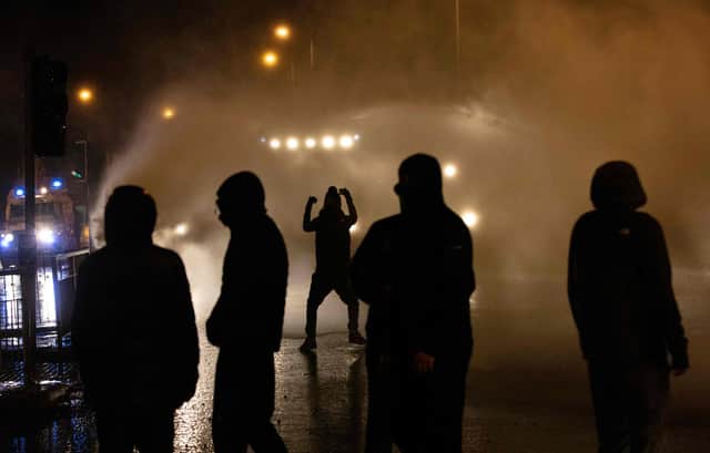Police officer use water cannon as they clash with youths in the Springfield Road area of Belfast (Picture: Paul Faith/AFP via Getty Images)