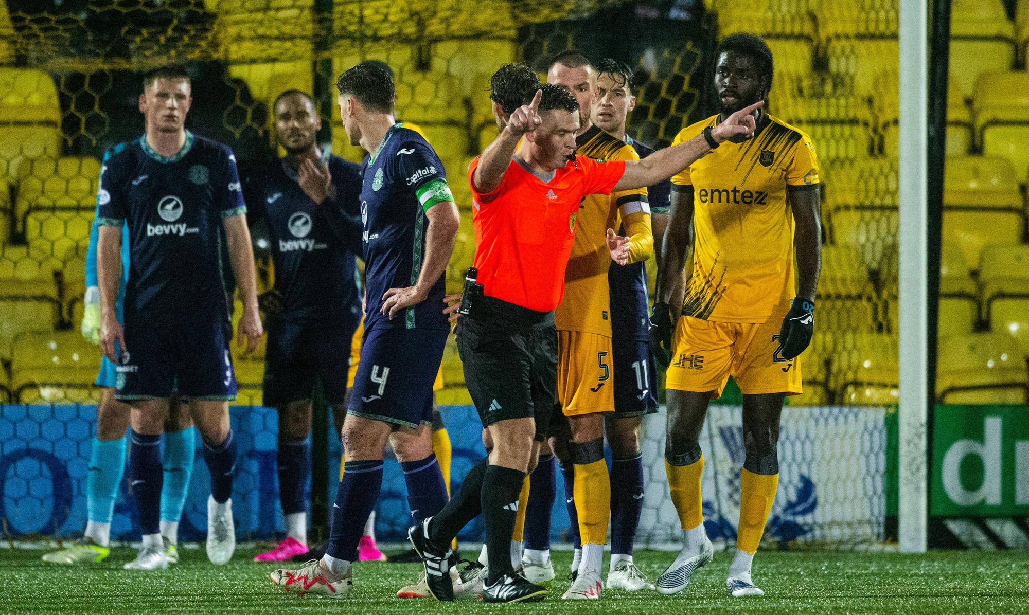 Referee Grant Irvine checks VAR during the match between Livingston and Hibs.