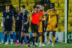 Referee Grant Irvine checks VAR during the match between Livingston and Hibs.