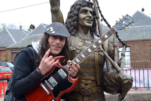 AC/DC fan Wayne Bovalentine poses with the Bon Scott statue.