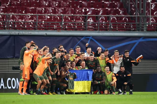 Shakhtar Donetsk players pose with the Ukrainian flag after the 4-1 win over RB Leipzig in Germany. (Photo by Cathrin Mueller/Getty Images)