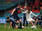LONDON, ENGLAND - JUNE 18: Jack Grealish of England runs with the ball whilst under pressure from Stephen O'Donnell and Che Adams of Scotland during the UEFA Euro 2020 Championship Group D match between England and Scotland at Wembley Stadium on June 18, 2021 in London, England. (Photo by Andy Rain - Pool/Getty Images)