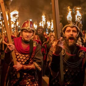Vikings from the Shetland South Mainland Up Helly Aa Jarl Squad lead the torchlight procession.