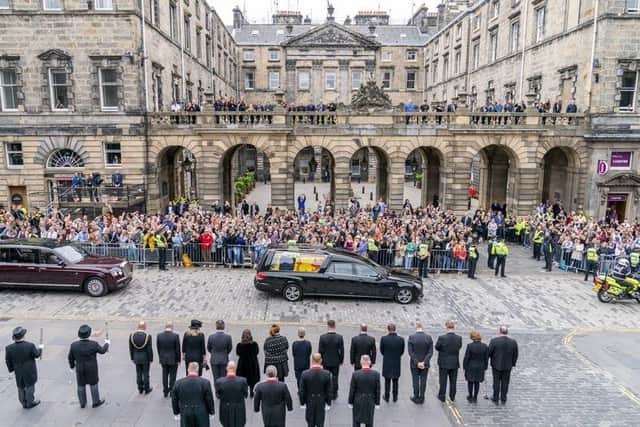 The hearse carrying the coffin of Queen Elizabeth II, draped with the Royal Standard of Scotland, passes the City Chambers on the Royal Mile