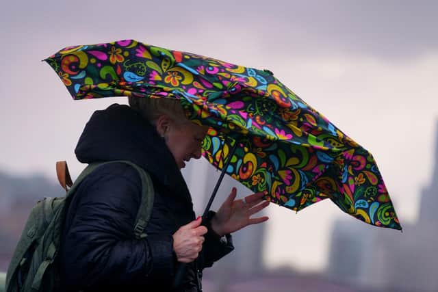A woman struggles with an umbrella as she walks over Westminster Bridge during high winds and wet weather in London. Photo: Victoria Jones/PA Wire