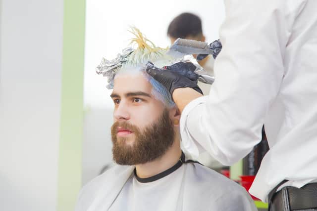 Process of a guy having his hair bleached at hairdresser.
