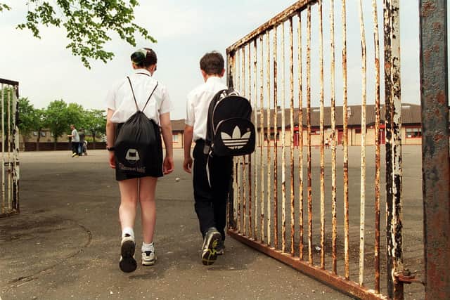 School pupils walking in to school through school gates