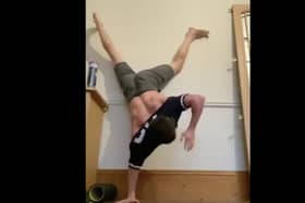 Tom Holland attempting to get a t-shirt on whilst doing a handstand (Photo: Tom Holland)