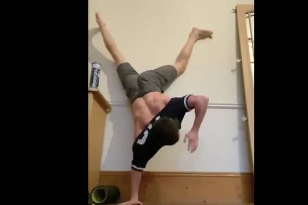 Tom Holland attempting to get a t-shirt on whilst doing a handstand (Photo: Tom Holland)