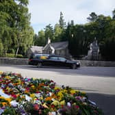 The hearse carrying the coffin of Queen Elizabeth II, draped with the Royal Standard of Scotland, leaves Balmoral on the beginning of its journey to Edinburgh