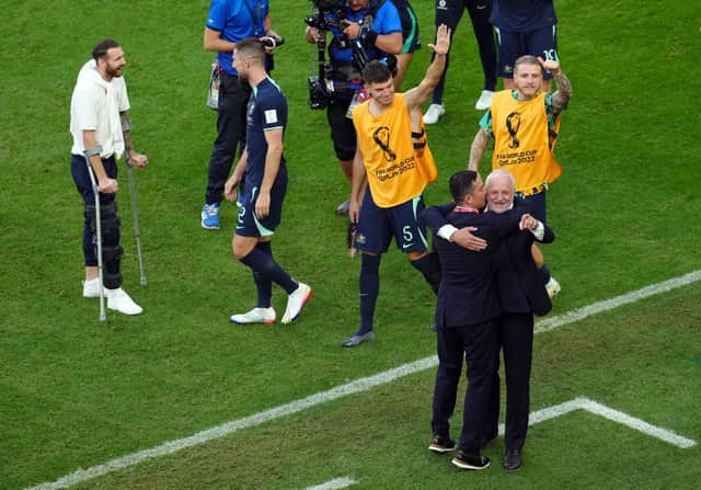 Boyle, pictured far left on crutches, has stayed with the Australian national team to support them at the World Cup.