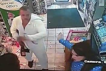 CCTV footage shows a Port Glasgow shopkeeper being spat on as a man in a unicorn onesie and the woman he was with try to rob two bottles of Buckfast