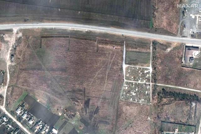 This satellite image provided by Maxar Technologies on Thursday, April 21, 2022 shows an overview of the cemetery in Manhush, some 20 kilometers west of Mariupol, Ukraine, on April 3, 2022. The graves are aligned in four sections of linear rows (measuring approximately 85 meters per section) and contain more than 200 graves. (Satellite image ©2022 Maxar Technologies via AP)