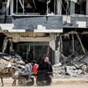 People ride a donkey-drawn cart moving past a destroyed building in Khan Yunis in the southern Gaza Strip. Picture: AFP via Getty Images