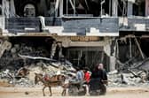 People ride a donkey-drawn cart moving past a destroyed building in Khan Yunis in the southern Gaza Strip. Picture: AFP via Getty Images