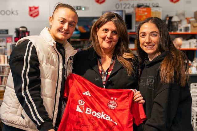 Emma Ilijoski and Kerry Beattie donate a signed shirt to the Salvation Army on the Great Northern Road, Aberdeen, for Green Football's Great Save.