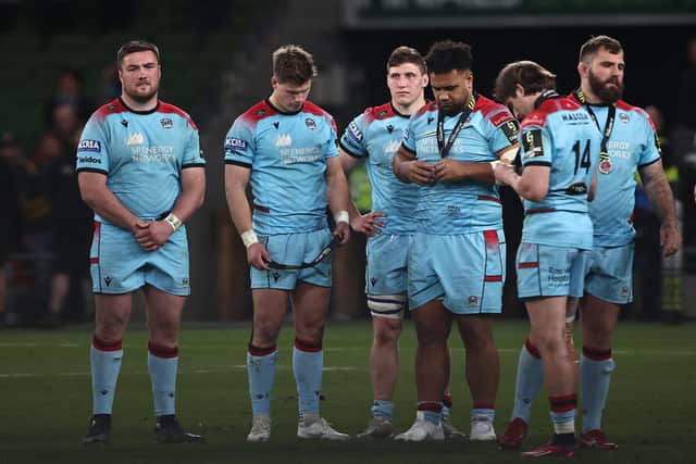 The dejected Glasgow Warriors players look at their medals following the 43-19 defeat by Toulon in Dublin. (Photo by Anne-Christine Poujoulat/AFP via Getty Images)