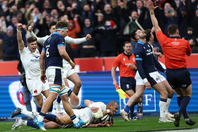 France centre Gael Fickou (bottom) scores the final try to condemn Scotland to a 32-21 defeat in Paris. (Photo by ANNE-CHRISTINE POUJOULAT/AFP via Getty Images)