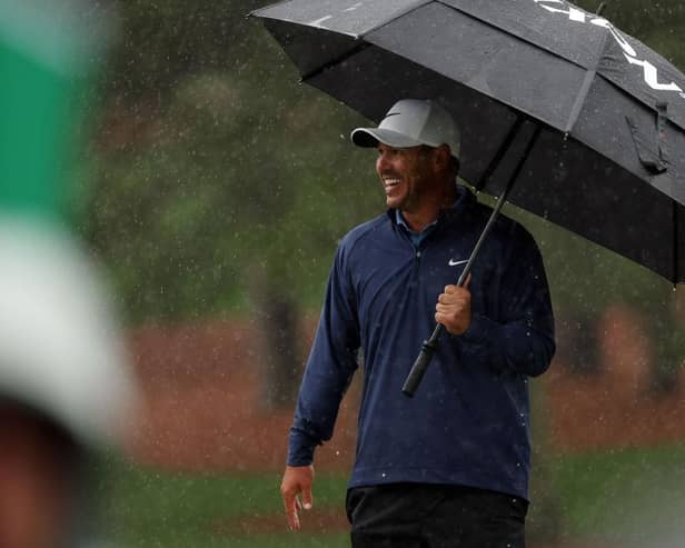 Brooks Koepka shelters under a brolley on a wet day at Augusta National Golf Club. Picture: Patrick Smith/Getty Images.