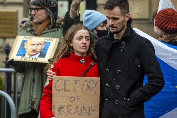 A couple of demonstrators holding a sign which reads "Get out of Ukraine". (Picture credit: Lisa Ferguson)