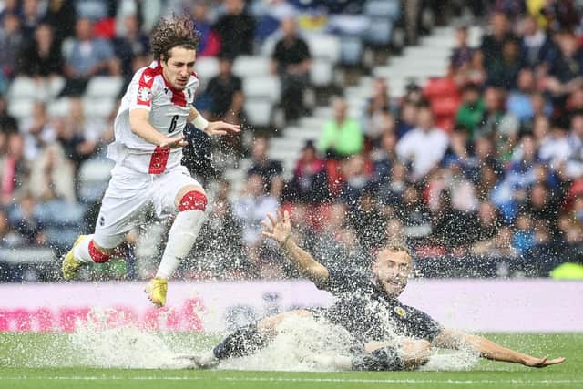 Ryan Porteous is submerged by standing water during the early stages of Scotland v Georgia at Hampden.