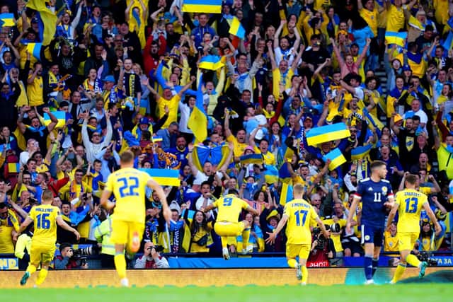 The Ukraine players and fans celebrate Roman Yaremchuk's goal at Hampden.