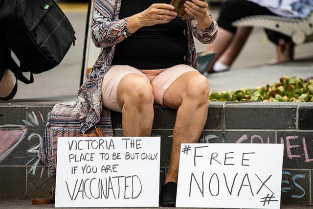 A Novak Djokovic supporter displays anti-vaccination signage as they gather outside Park Hotel where Djokovic was taken pending his removal from the country.