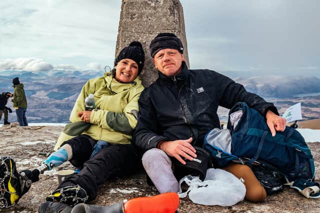 A well earned rest against the trig point at the summit of Ben Nevis for Paul Ellis and a member of his support team.