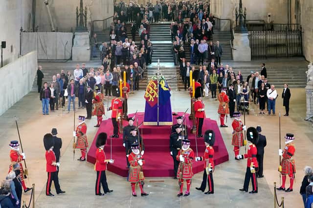 Members of the public file past the coffin of Queen Elizabeth II, draped in the Royal Standard with the Imperial State Crown and the Sovereign's orb and sceptre, lying in state on the catafalque in Westminster Hall, at the Palace of Westminster, London, ahead of her funeral on Monday. Picture date: Thursday September 15, 2022.
