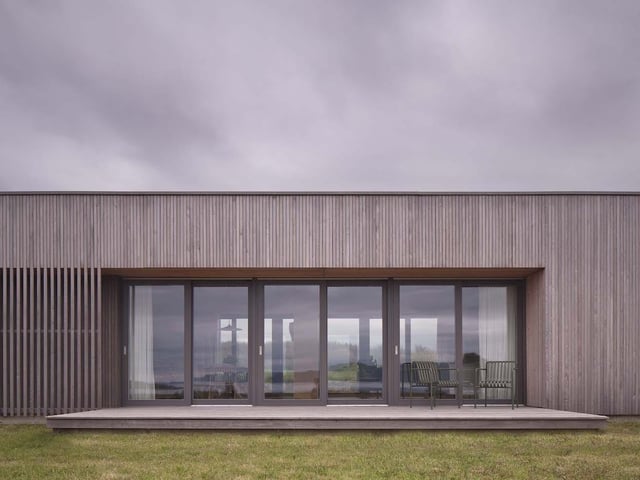 Half of Eleven was designed by Dualchas Architects as a self-build house, which the owners have built themselves on a modest budget as they work to regenerate their long-held but neglected croft in the coastal township of Breakish. The new house appears as a simple and unobtrusive addition to the landscape, with large windows in the main living space providing beautiful views, and timber cladding used to allow the building to blend naturally with its surroundings. The extensive use of timber continues inside, bringing texture and warmth to the home’s bright and airy spaces. This project demonstrates that architecture does not need large footprints and budgets to create rural buildings of great character.