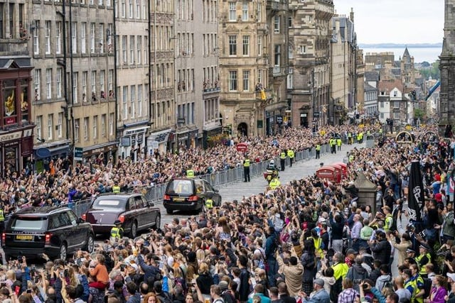 The hearse carrying the coffin of Queen Elizabeth II, draped with the Royal Standard of Scotland, passes down the Royal Mile