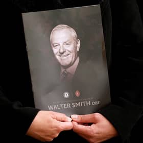 A person holds the order of service during Walter Smith's memorial service at Glasgow Cathedral.
