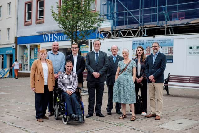 Community wealth minister Tom Arthur, centre, with members of Midsteeple Quarter, other project funders and contractors in front of the construction site on Dumfries High Street.