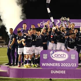 Dundee players celebrate with the trophy after winning the Championship in dramatic fashion, overcoming Queen's Park 5-3 at Ochilview.