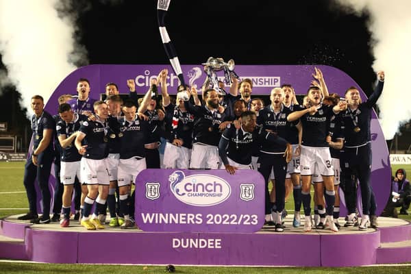 Dundee players celebrate with the trophy after winning the Championship in dramatic fashion, overcoming Queen's Park 5-3 at Ochilview.