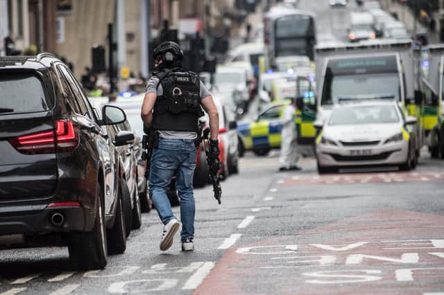 An armed officer at the scene of the stabbings of six people in Glasgow. The suspect was shot dead by police (Picture: John Devlin)