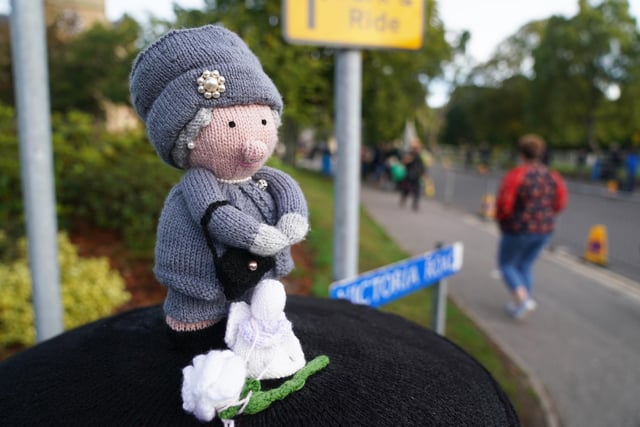 A knitted topper of Queen Elizabeth II has been placed on a post box in Ballater, Scotland. The Queen's coffin will be transported on a six-hour journey from Balmoral to the Palace of Holyroodhouse in Edinburgh, where it will lie at rest.  (Pic: PA/Andrew Milligan)