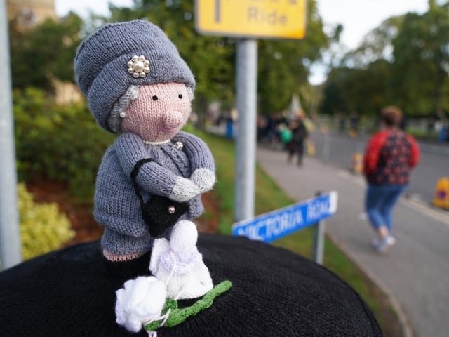 A knitted topper of Queen Elizabeth II has been placed on a post box in Ballater, Scotland. The Queen's coffin will be transported on a six-hour journey from Balmoral to the Palace of Holyroodhouse in Edinburgh, where it will lie at rest. (Pic: PA/Andrew Milligan)