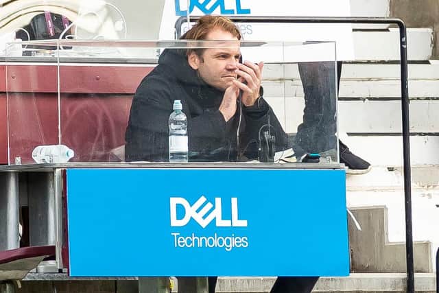 Hearts Manager Robbie Neilson watches on from the stand.
