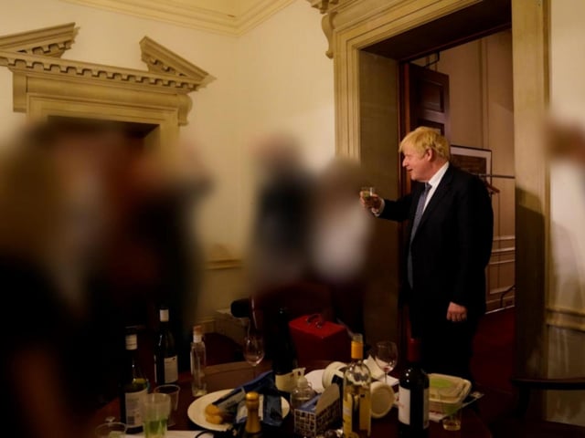 Boris Johnson is pictured with a drink during the same event for the departure of a special advisor at No 10 Downing Street.
