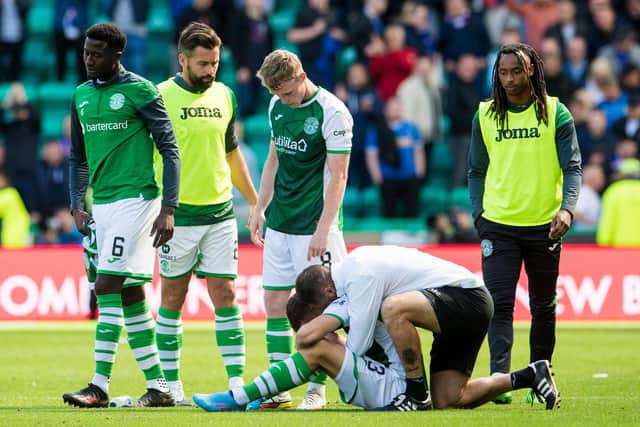 Hibs assistant manager Jamie McAllister and several players attempt to console the recently-bereaved Marijan Cabraja at the conclusion of their league draw with Rangers. Photo by Ross Parker / SNS Group