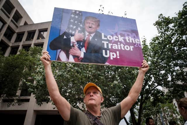 A person holds up a sign with a photograph of former President Donald Trump outside of the E. Barrett Prettyman United States Courthouse in Washington, DC. President Donald Trump arrived at the Courthouse to be arraigned on Thursday afternoon after being indicted on four felony counts for his alleged efforts to overturn the 2020 election.