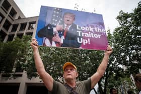 A person holds up a sign with a photograph of former President Donald Trump outside of the E. Barrett Prettyman United States Courthouse in Washington, DC. President Donald Trump arrived at the Courthouse to be arraigned on Thursday afternoon after being indicted on four felony counts for his alleged efforts to overturn the 2020 election.