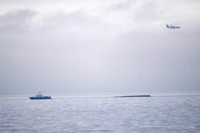 The capsized Danish cargo ship Karin Hoej (R) is pictured on the Baltic Sea, between the Swedish city of Ystad and the Danish island of Bornholm, after colliding with the British cargo ship Scot Carrier early Monday morning.